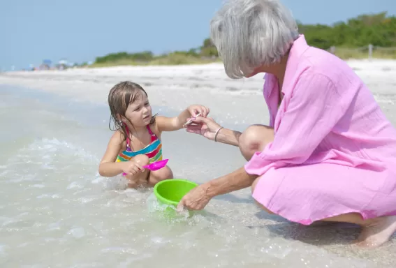 Woman and child searching for shells on beach